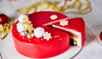 Mousse Christmas pastry cake dessert covered with red mirror glaze with new year decorations