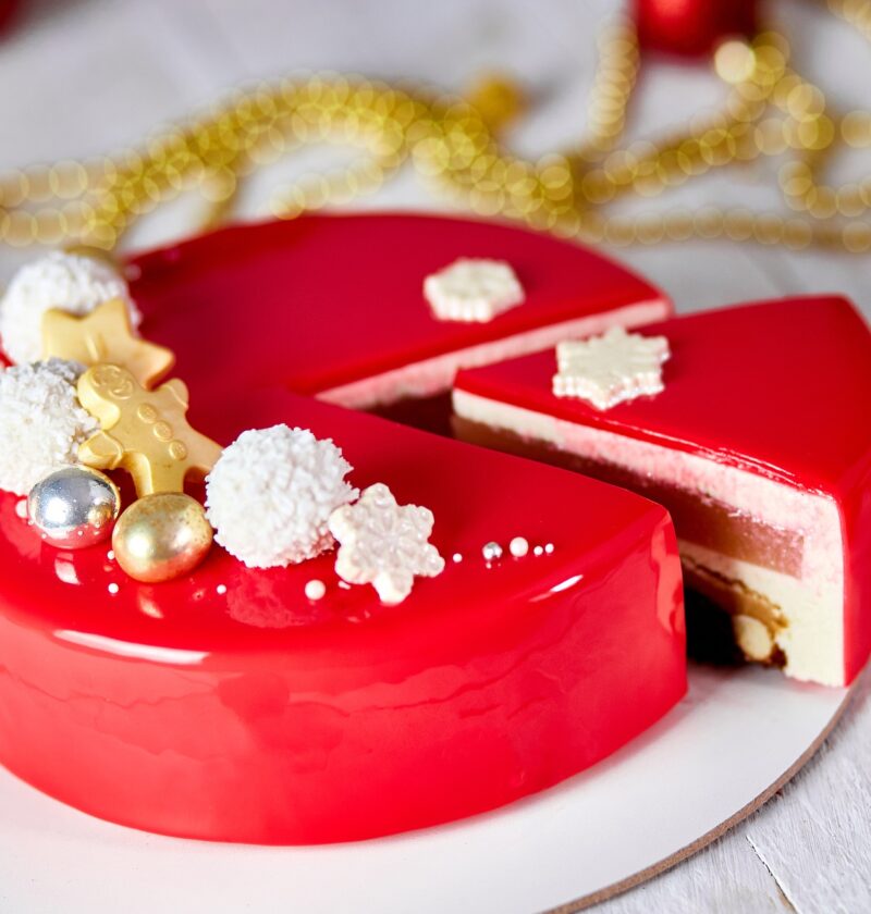 Mousse Christmas pastry cake dessert covered with red mirror glaze with new year decorations
