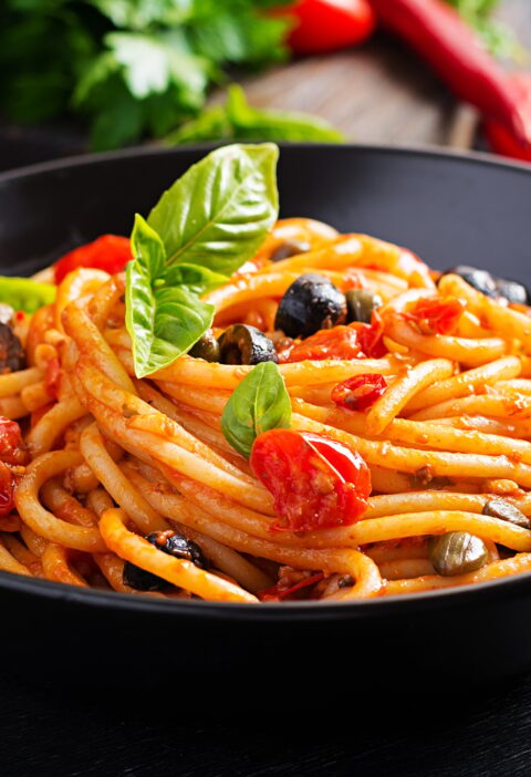 Spaghetti alla puttanesca - italian pasta dish with tomatoes