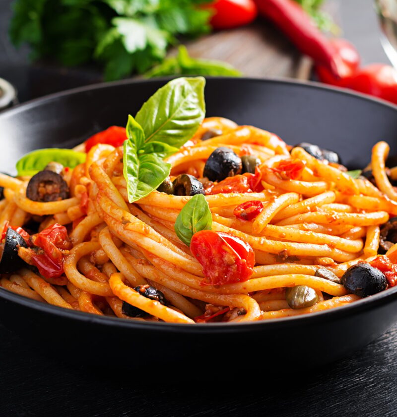 Spaghetti alla puttanesca - italian pasta dish with tomatoes