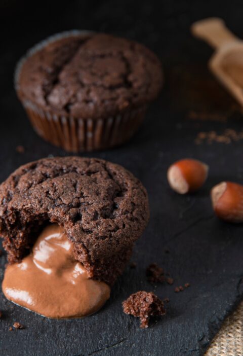 baked hot chocolate fondant with hazelnut, cinnamon and leaked filling on black shale background