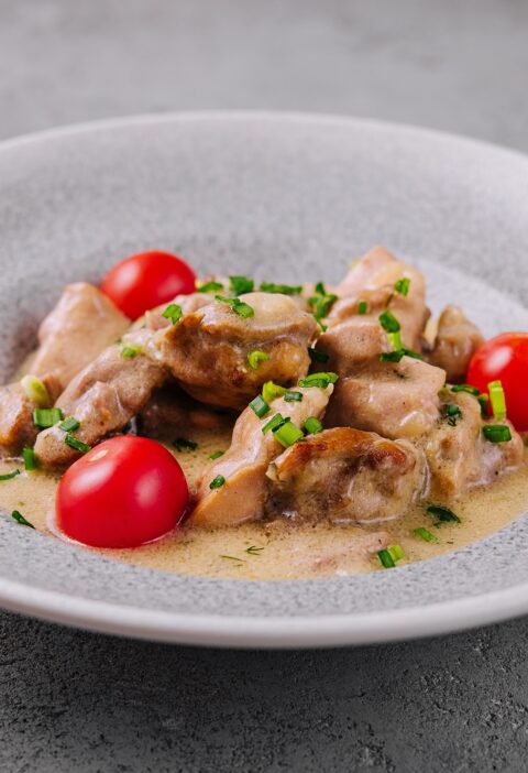 Grilled chicken breast with cream sauce and tomatoes