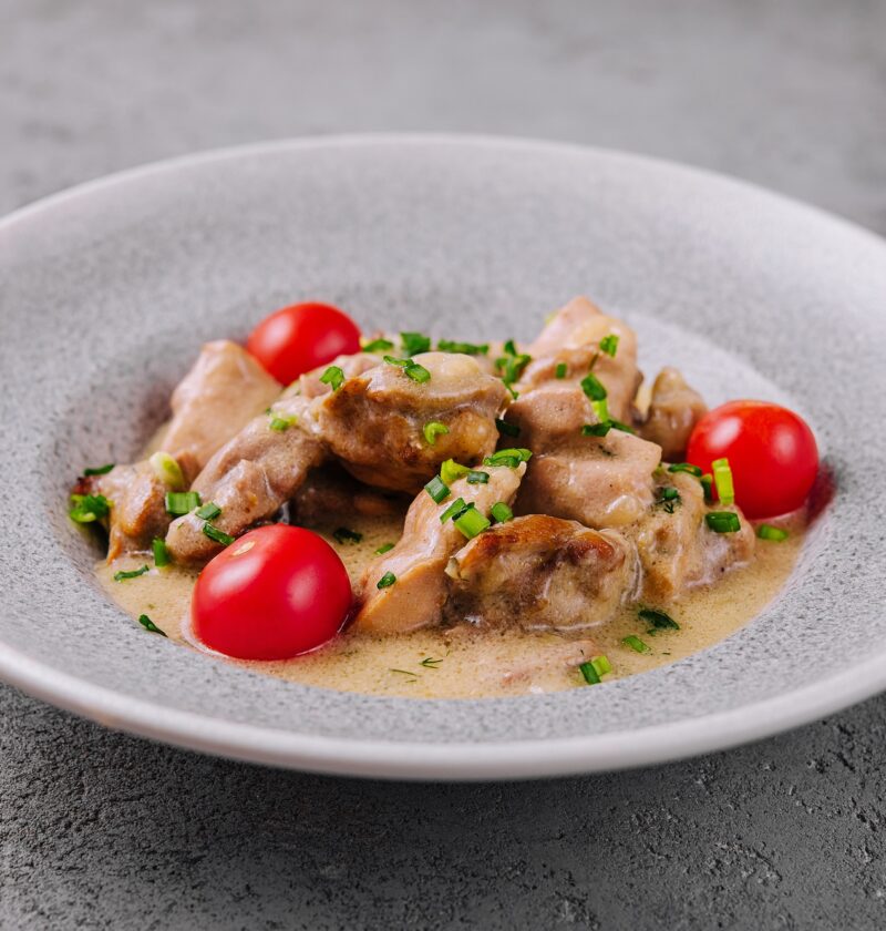 Grilled chicken breast with cream sauce and tomatoes
