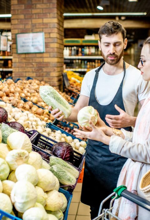 Shop worker with woman in the supermarket