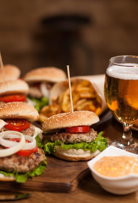 Best happy hour burgers with cold beer on a restaurant wooden table