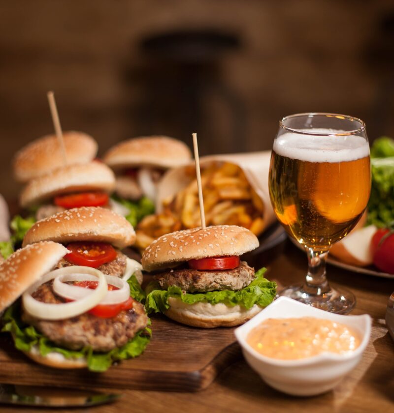 Best happy hour burgers with cold beer on a restaurant wooden table