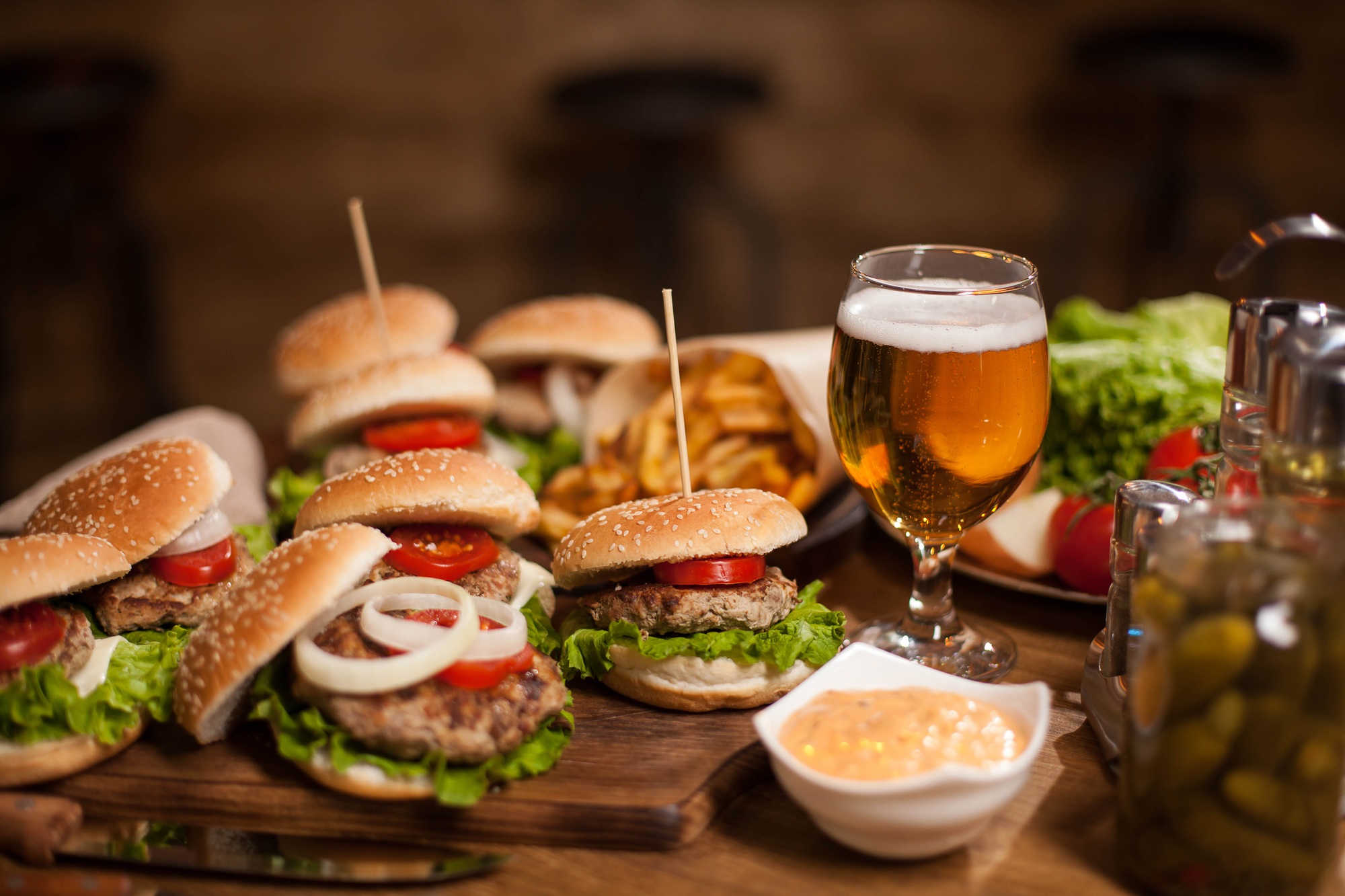 Best happy hour burgers with cold beer on a restaurant wooden table