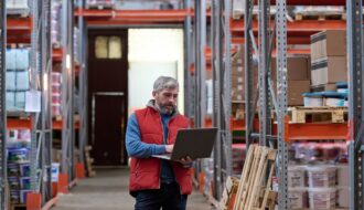 Distributor using laptop at warehouse