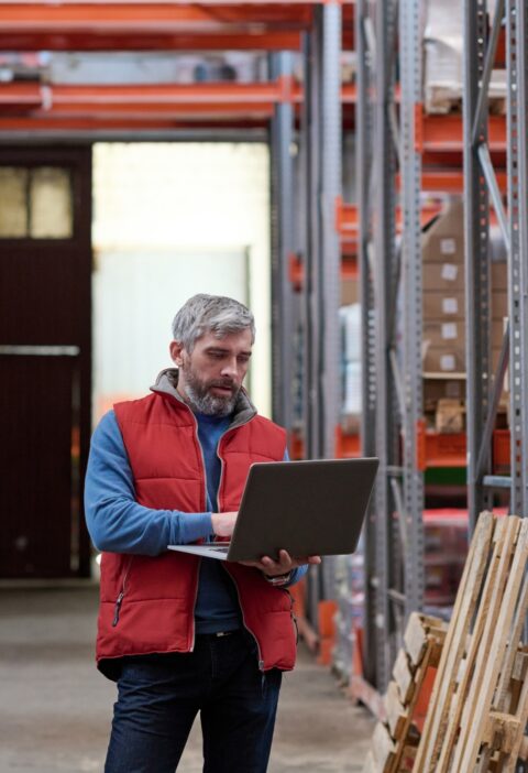 Distributor using laptop at warehouse