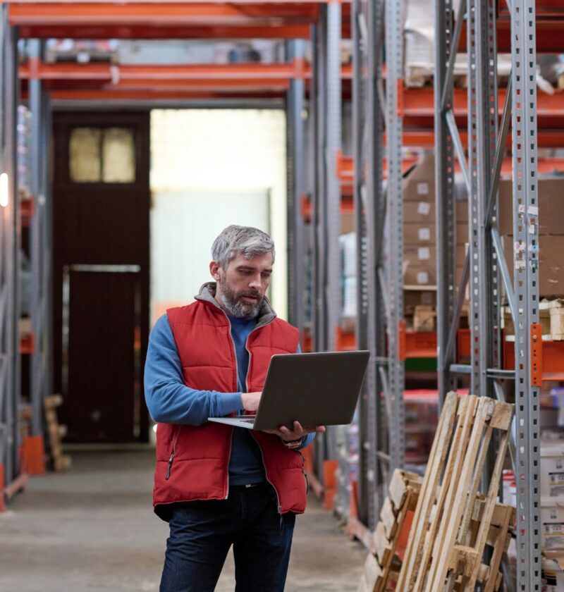 Distributor using laptop at warehouse