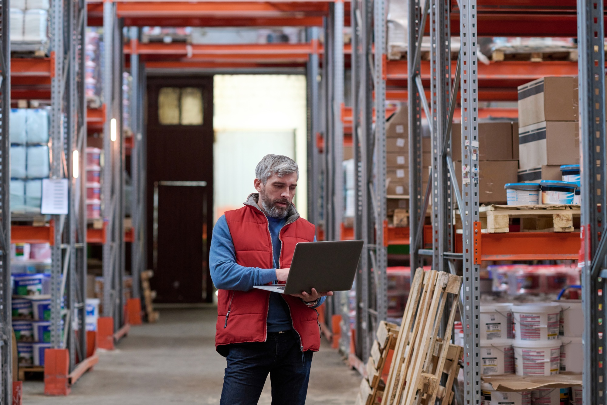 Distributor using laptop at warehouse