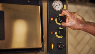 Male chef regulating switchers on professional oven