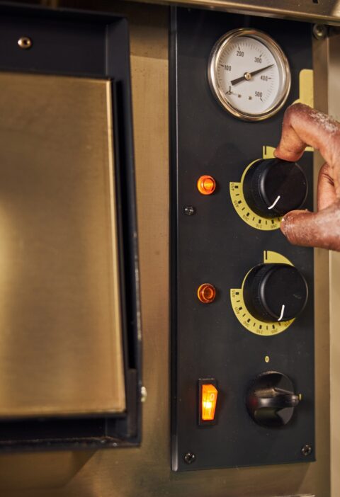 Male chef regulating switchers on professional oven