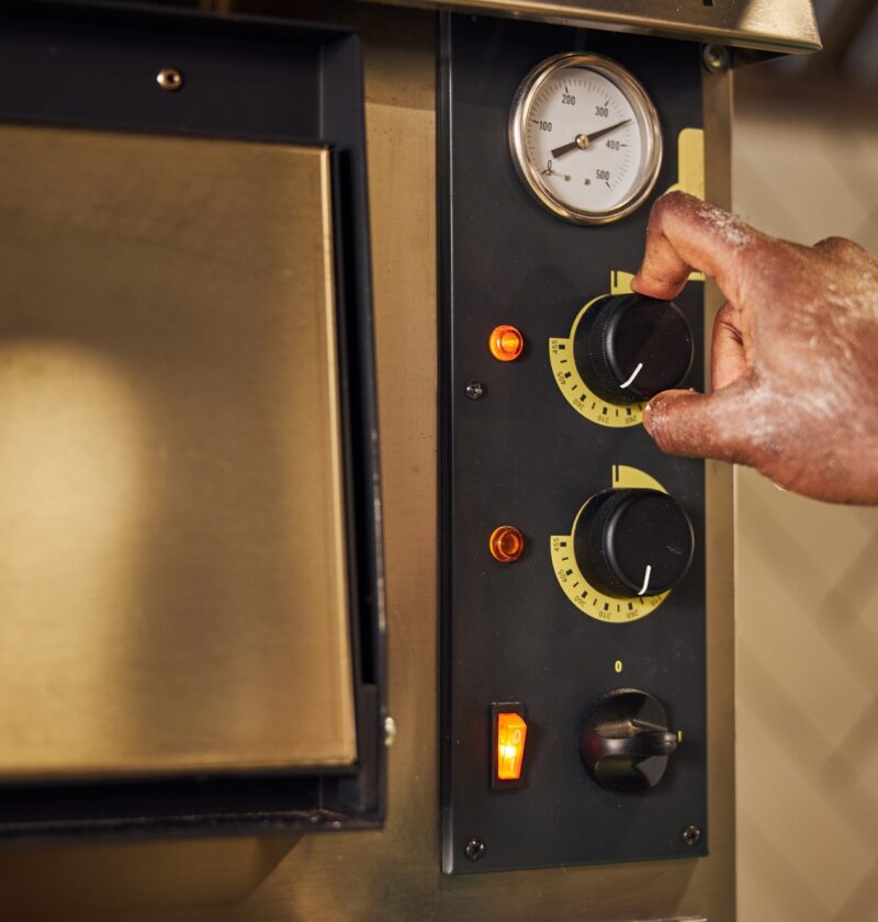 Male chef regulating switchers on professional oven
