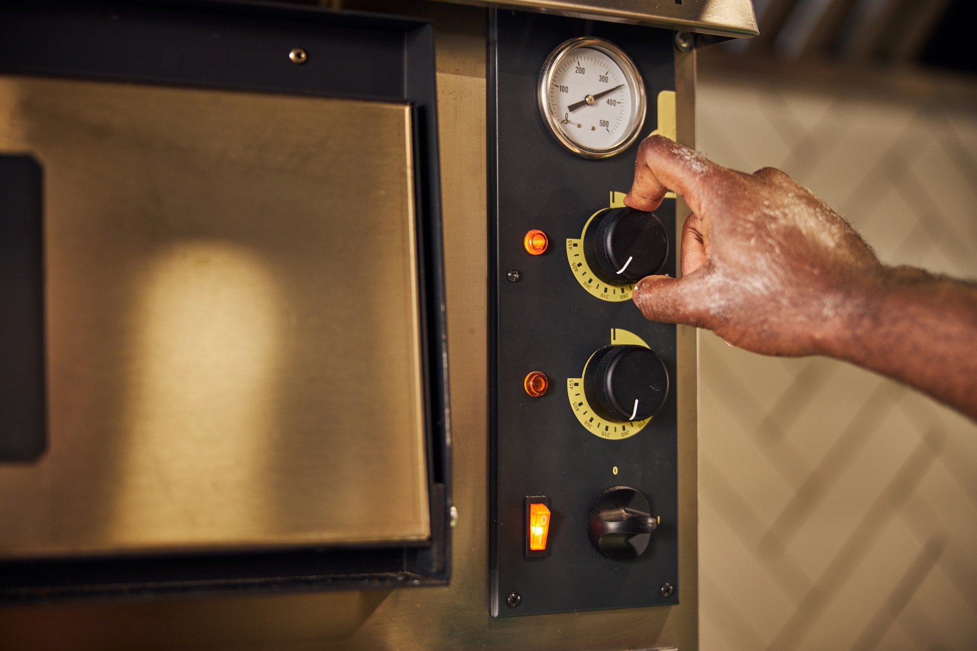 Male chef regulating switchers on professional oven